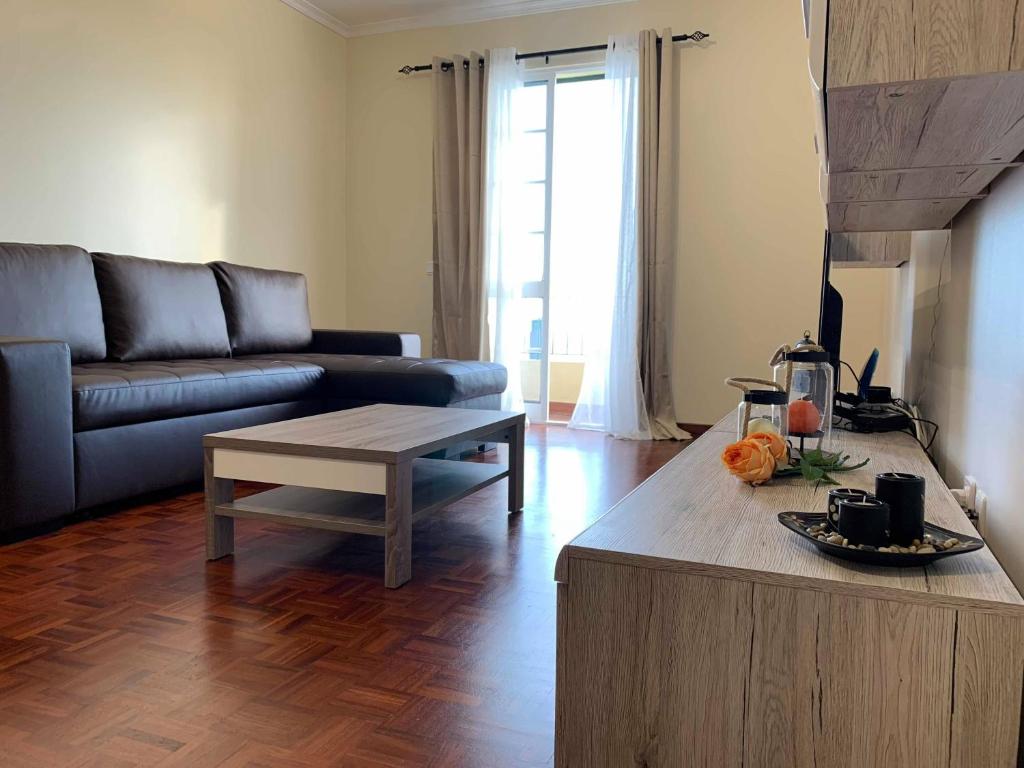 een woonkamer met een bank en een salontafel bij Ilha Atlântico in Caniço