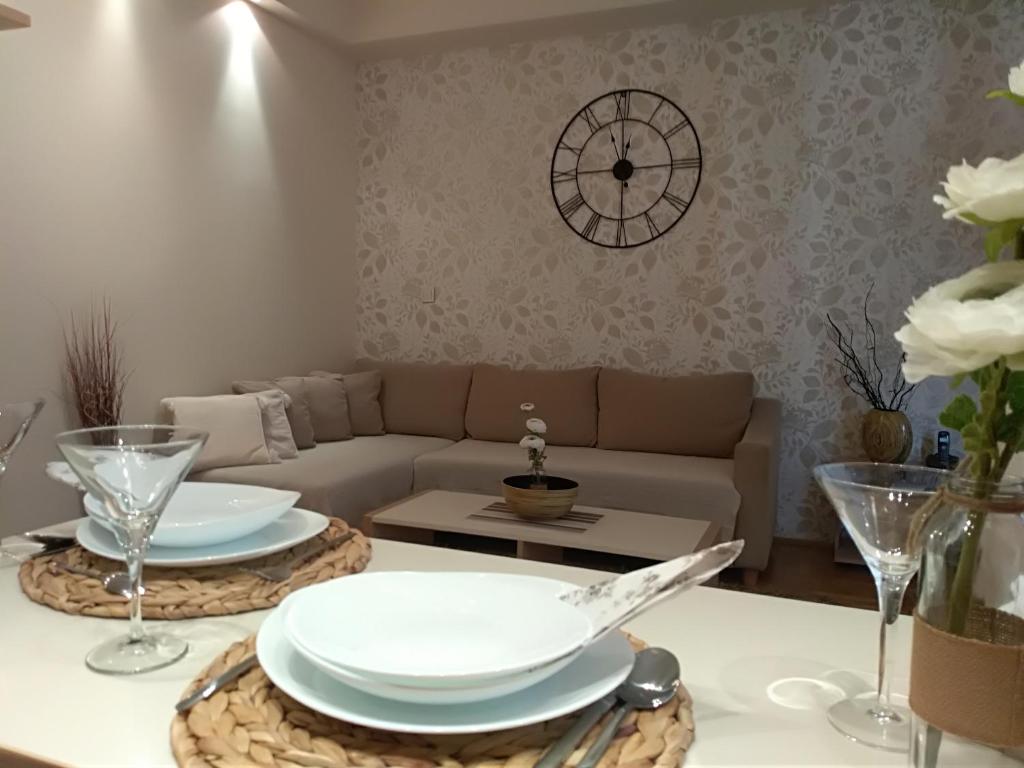 sala de estar con sofá y mesa con platos en Nina, en Voždivac