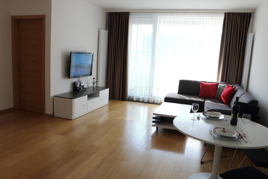 ein Wohnzimmer mit einem Sofa und einem Tisch in der Unterkunft Panorama City Apartment with Free Parking in Bratislava