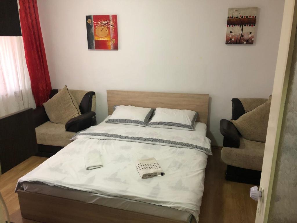 una camera con un letto e due sedie di Garsoniera Centru a Bacău