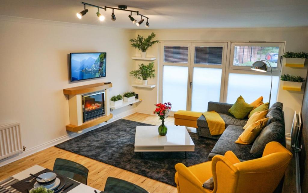 a living room with a couch and a fireplace at Hydro Apartment with free car park in Glasgow