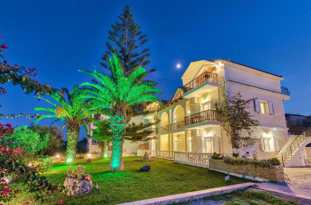 a large house with a palm tree in the yard at Panorama Studios & Apartments in Amoudi