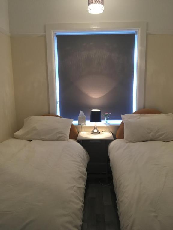two beds in a room with a window at Oxford Avenue in Bournemouth