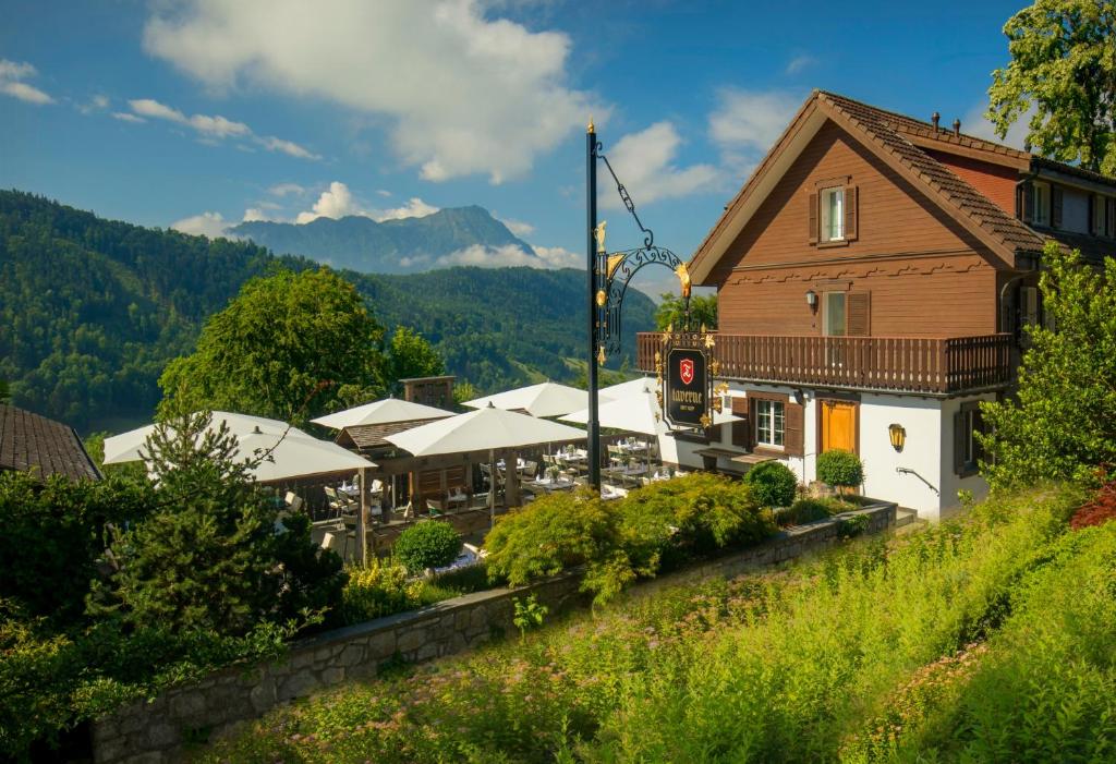 un edificio de madera con una montaña en el fondo en Bürgenstock Hotels & Resort - Taverne 1879 en Bürgenstock