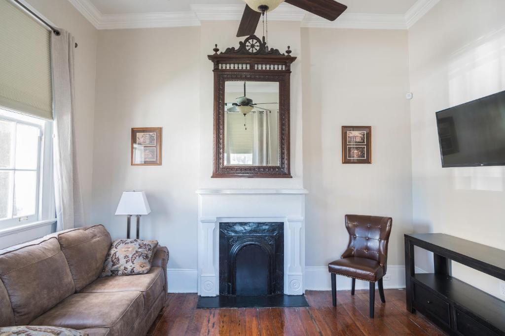 een woonkamer met een bank en een spiegel bij Crescent City Cottage in New Orleans