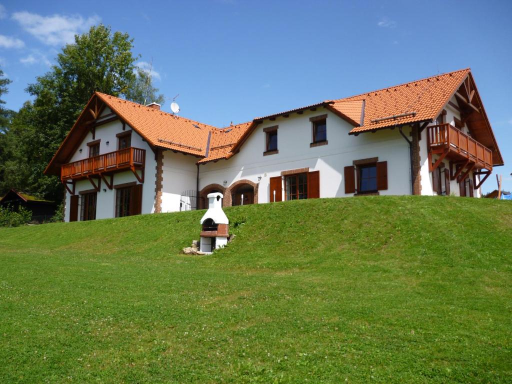 ein Haus auf einem Grashügel in der Unterkunft Villa Victoria in Lipno nad Vltavou