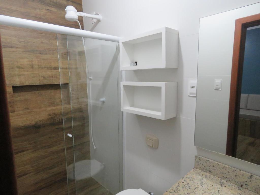 a bathroom with a shower with a glass door at Residencial Sol e Lua in Palhoça