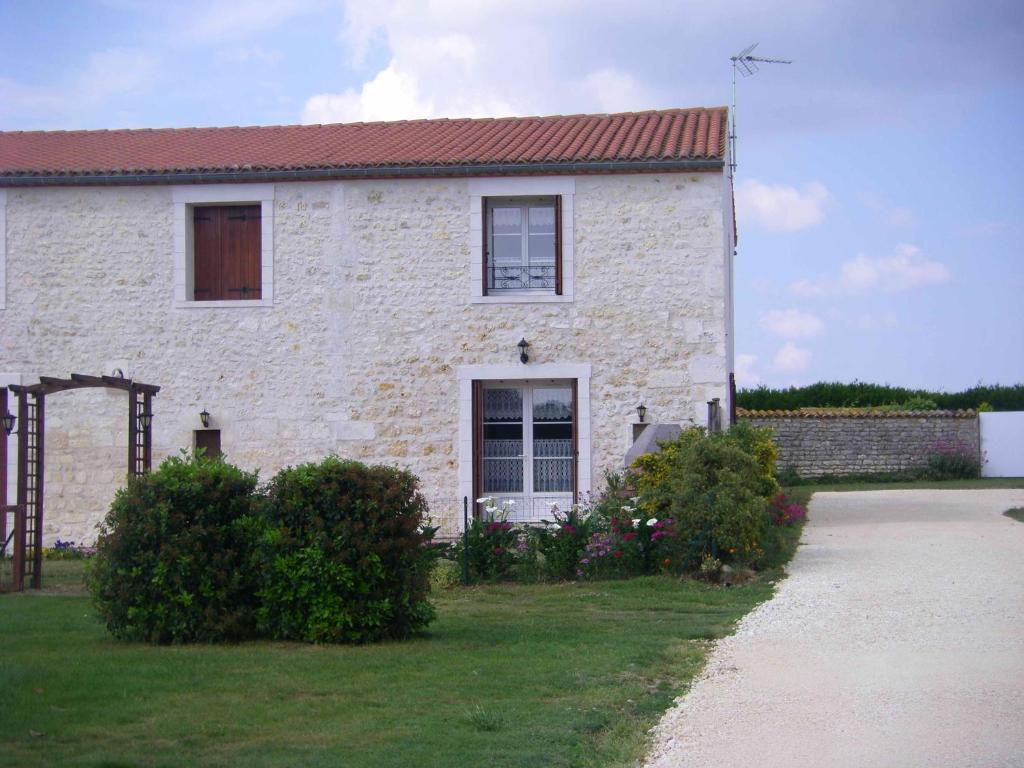 una casa de ladrillo blanco con techo rojo en Gite à Sablonceaux pres de de royan et la palmyre, en Sablonceaux