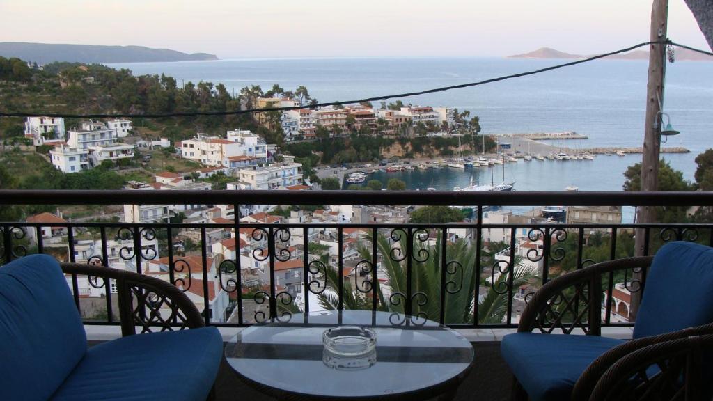 balcone con tavolo, sedie e vista sull'oceano di Captain George's Apartments a Patitiri