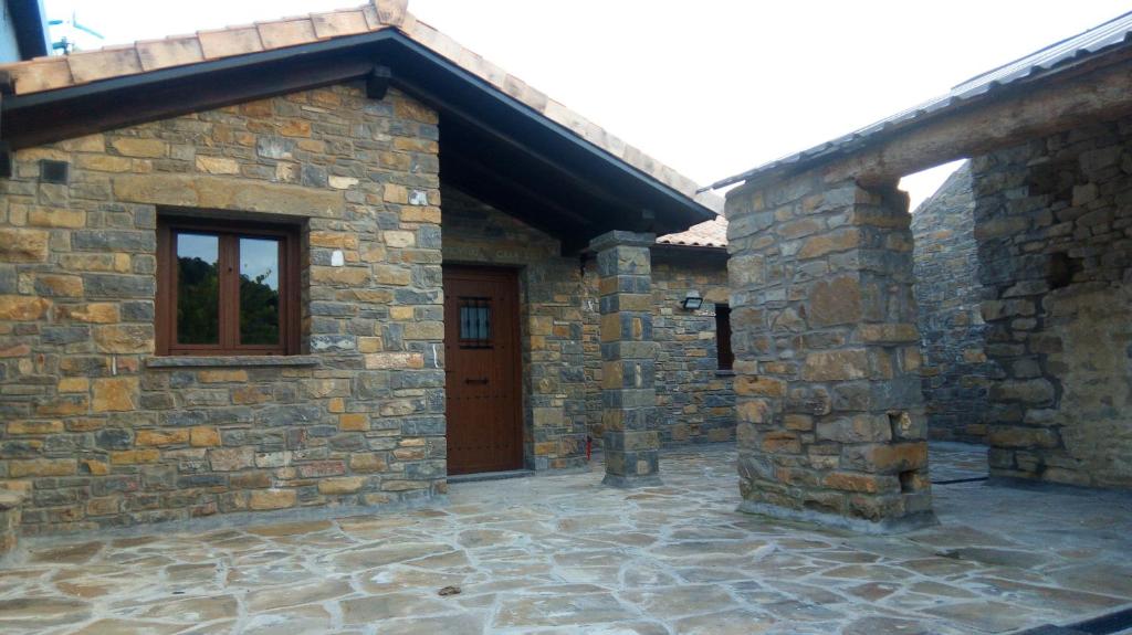a stone house with a wooden door and a patio at BanastónEra in Usana