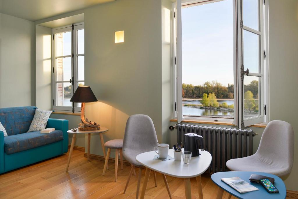- un salon avec un canapé, une table et des chaises dans l'établissement Suites du Cabinet Vert, à Orléans