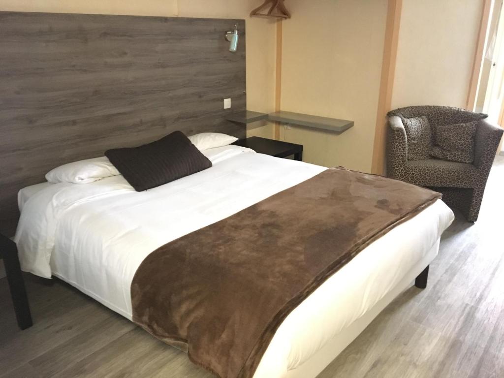 1 dormitorio con 1 cama grande y 1 silla en Aix Hotel, en Aix-en-Provence