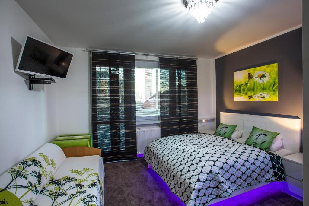 Un dormitorio con una cama y un televisor y una ventana. en Studio Apartment Petrzalka Air-Conditioned 24h check-in, en Bratislava