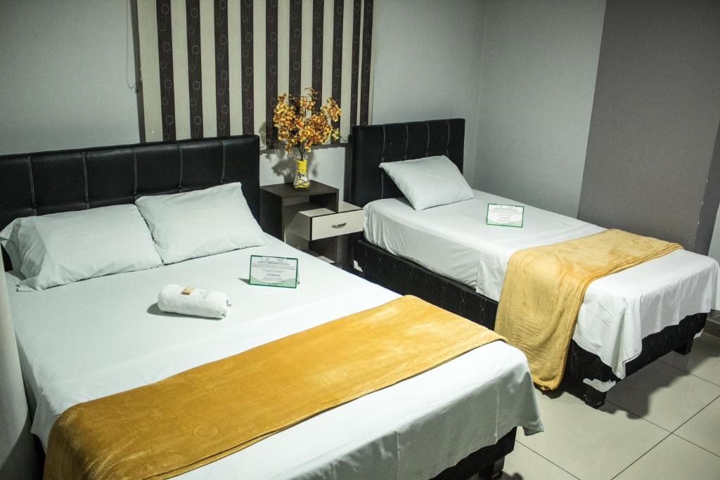 Postel nebo postele na pokoji v ubytování Hotel Escorial Ibagué