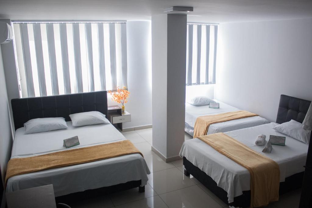 Postel nebo postele na pokoji v ubytování Hotel Escorial Ibagué