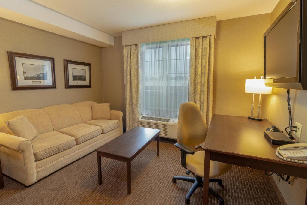 a living room with a couch and a desk at The Kanata Fort Saskatchewan in Fort Saskatchewan