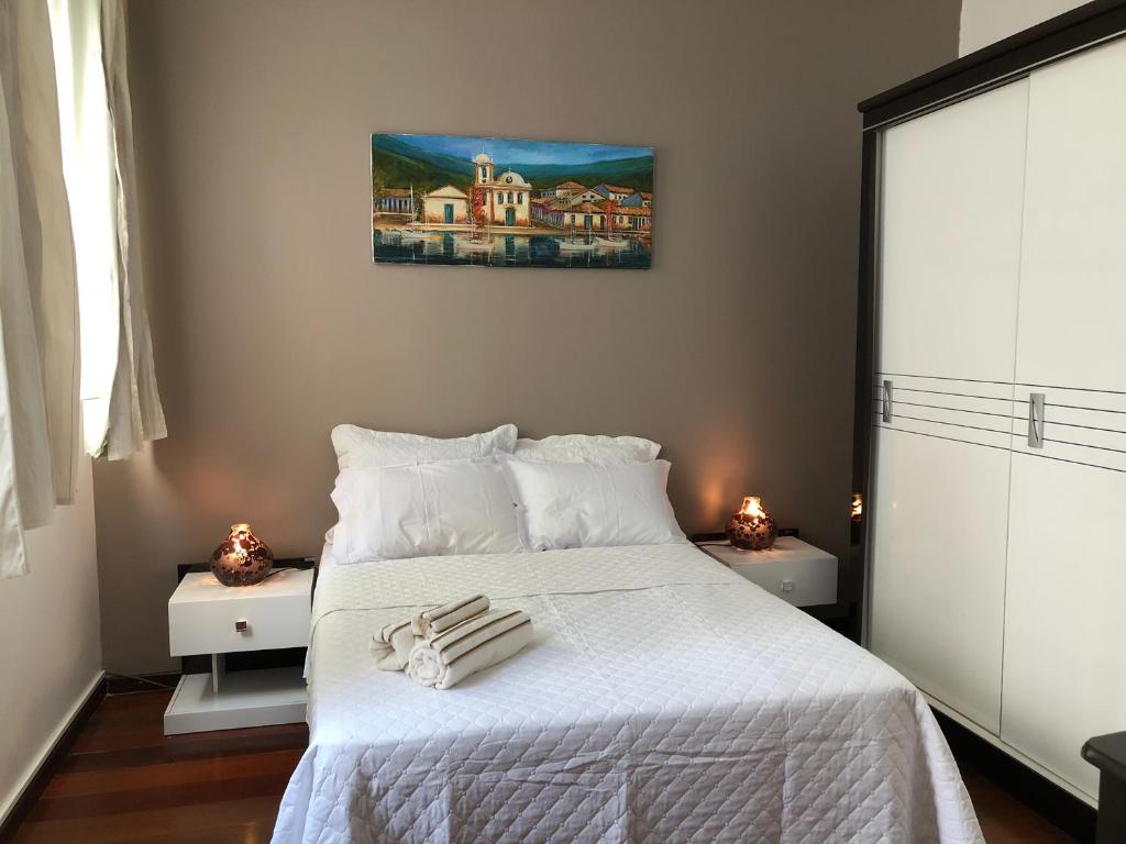 1 dormitorio con 1 cama con sábanas blancas y toallas. en Apartamento 3 quartos Rio, en Río de Janeiro