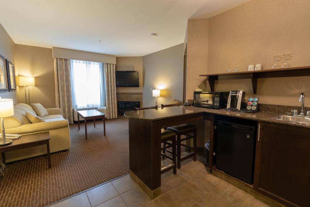 a hotel room with a kitchen and a living room at The Kanata Fort Saskatchewan in Fort Saskatchewan