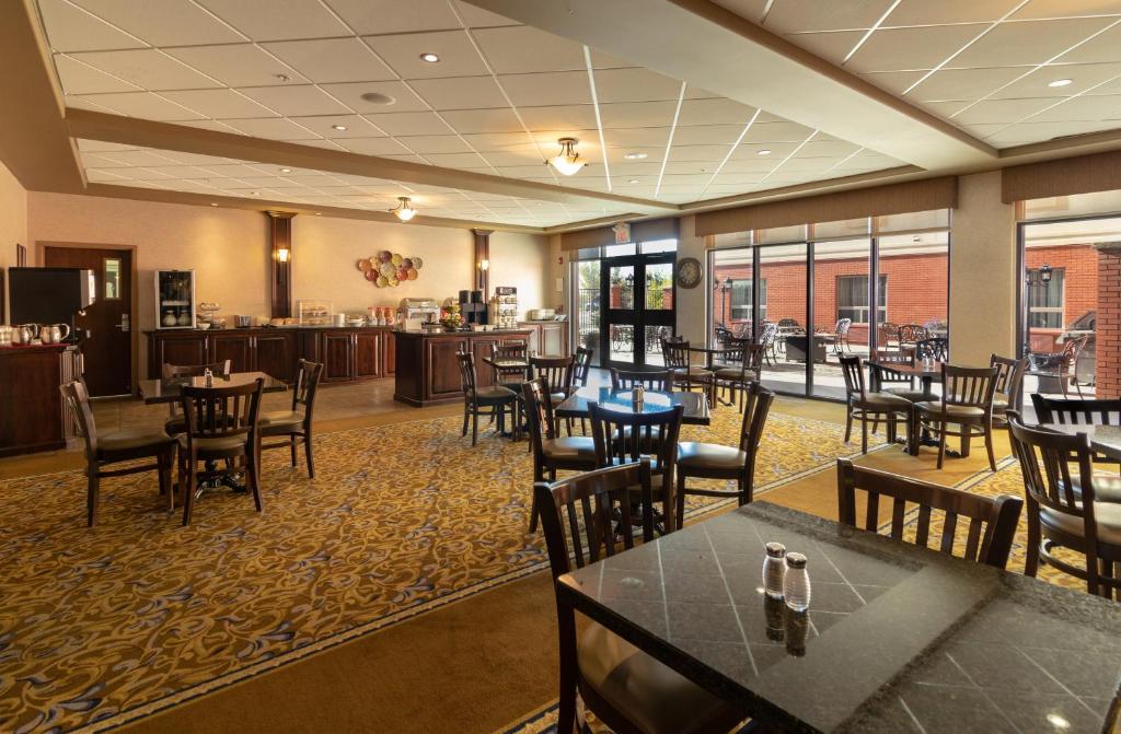 a restaurant with tables and chairs and a bar at The Kanata Fort Saskatchewan in Fort Saskatchewan