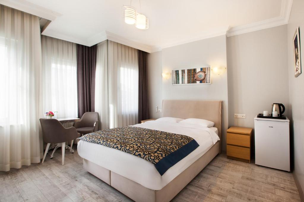 イスタンブールにあるSultanahmet inn Hotelのベッド、デスク、テーブルが備わる客室です。