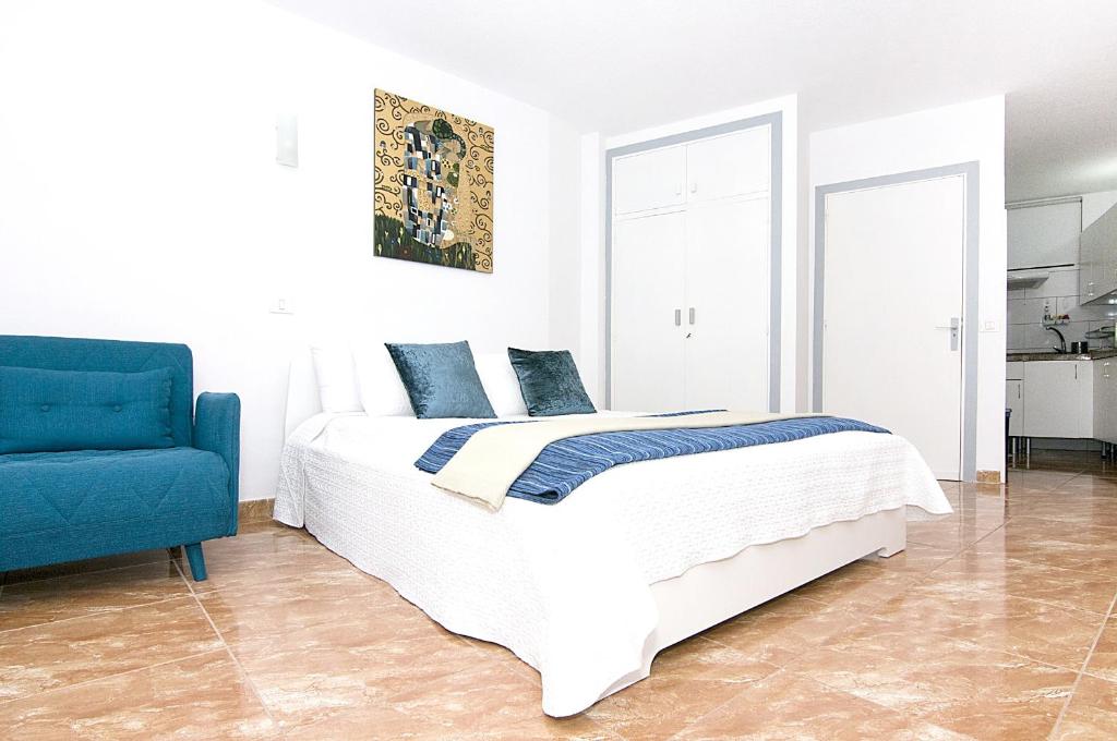 タコロンテにあるBalcón del Marのベッドルーム1室(ベッド1台、青い椅子付)