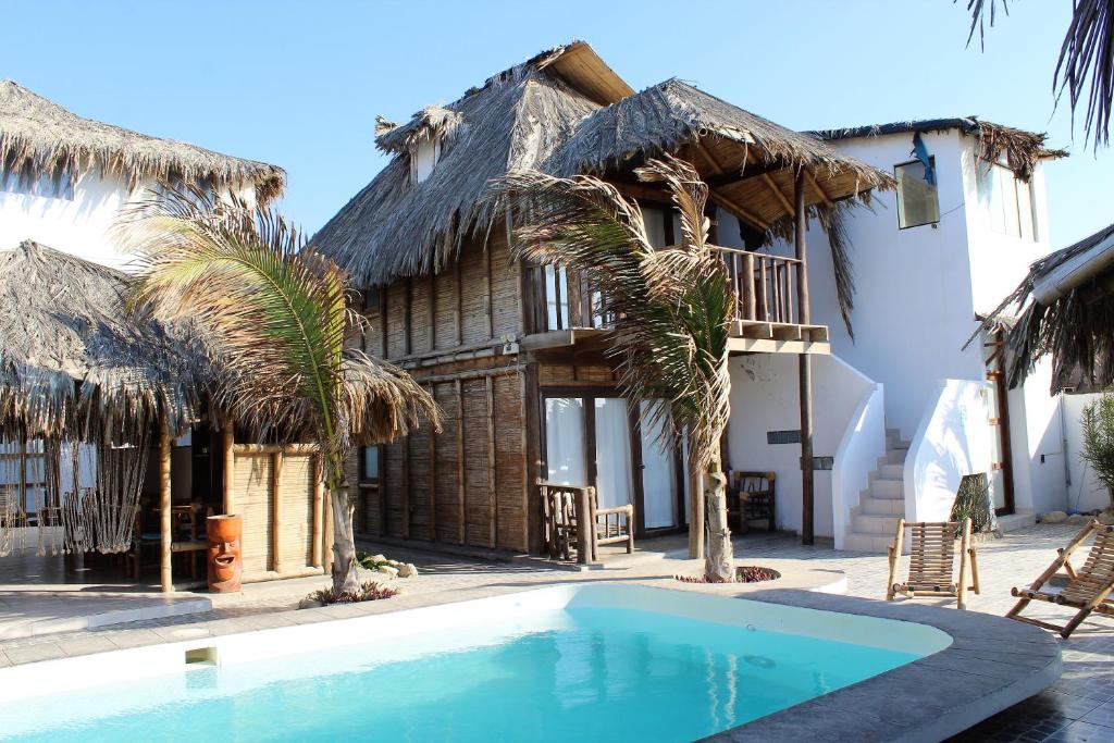 a house with a swimming pool in front of it at Hotel Puerto Antiguo in Los Órganos