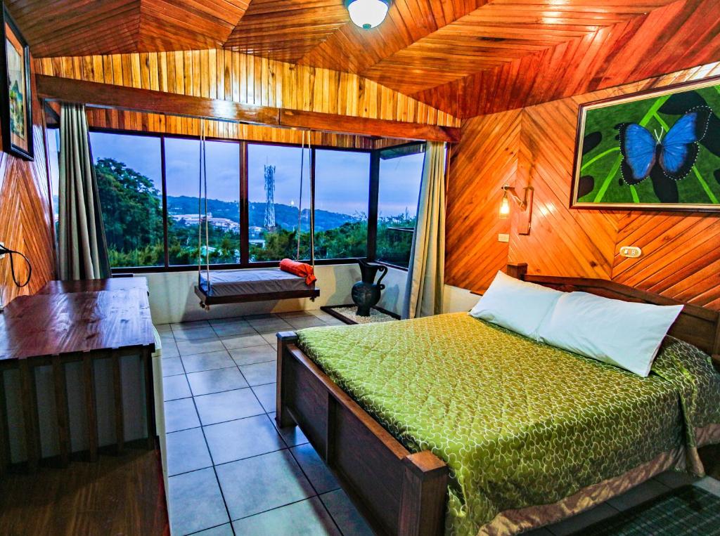 - une chambre avec un lit et une grande fenêtre dans l'établissement Hotel Don Taco, à Monteverde Costa Rica
