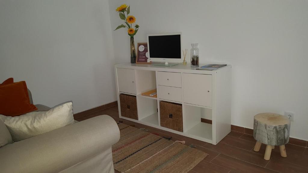 a living room with a white cabinet with a computer on it at Casa dos Avós in Villa Nogueira