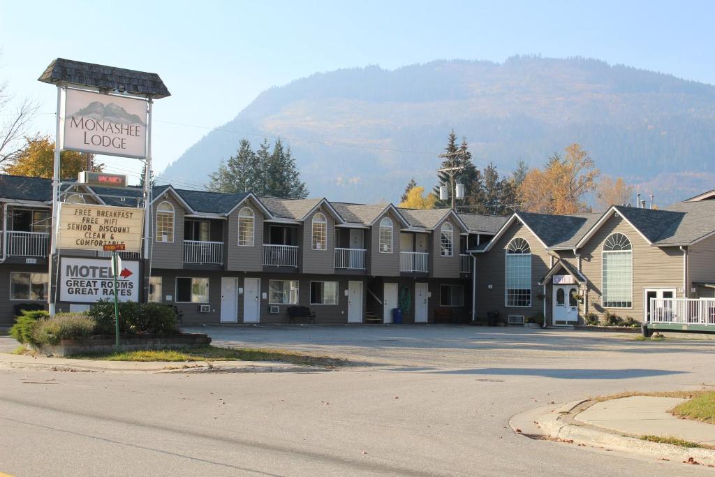 a row of houses in a parking lot with a sign at Monashee Lodge in Revelstoke