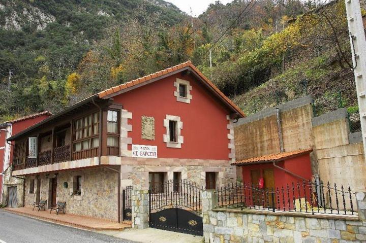 a red building on the side of a mountain at Posada El Cafetín in La Hermida