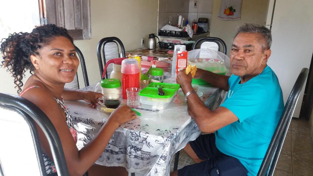 a man and a woman sitting at a table at Pousada Beira Rio in Santo Amaro