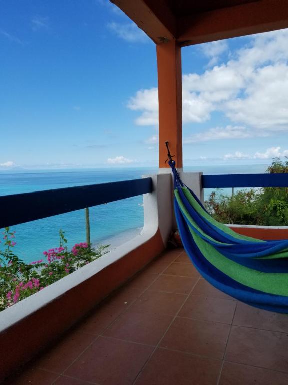 uma rede de descanso numa varanda com vista para o oceano em Orrie's Beach Bar and Hotel em Crab Hill