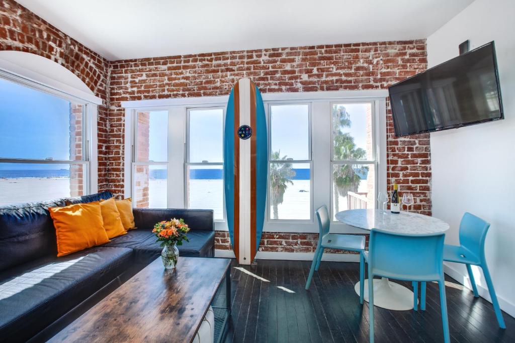 a living room with a couch and a surfboard at Venice Breeze Suites in Los Angeles