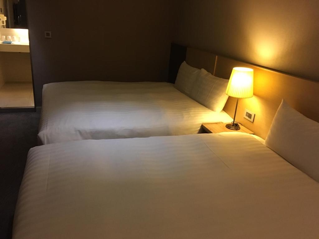 Postel nebo postele na pokoji v ubytování 麗馨商旅七賢館