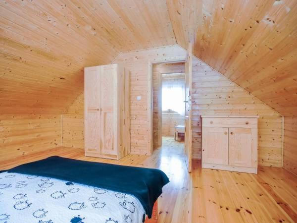 a bedroom with a bed in a wooden cabin at Agromarko in Ustronie Morskie
