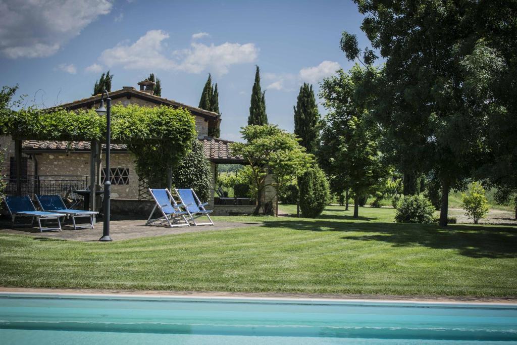 una casa con un patio con sillas y una piscina en Monteriggioni Suite en Monteriggioni