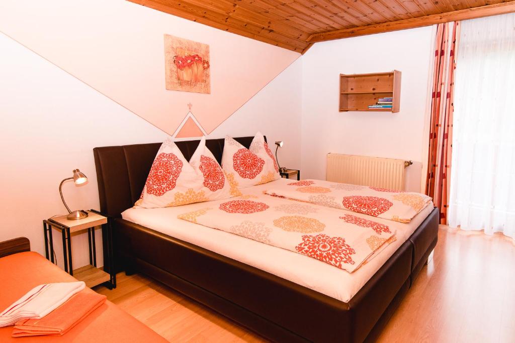 ein Schlafzimmer mit einem großen Bett mit rosa Kissen in der Unterkunft Haus Lassacher in Sankt Michael im Lungau