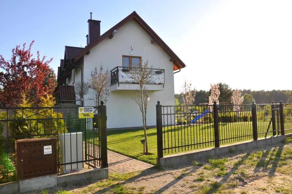 a fence in front of a white house at Gościniec Kaszubski Homestay in Białogóra