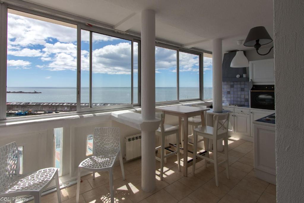 a kitchen with a balcony with a view of the ocean at L'Eternel Estivant in Sète