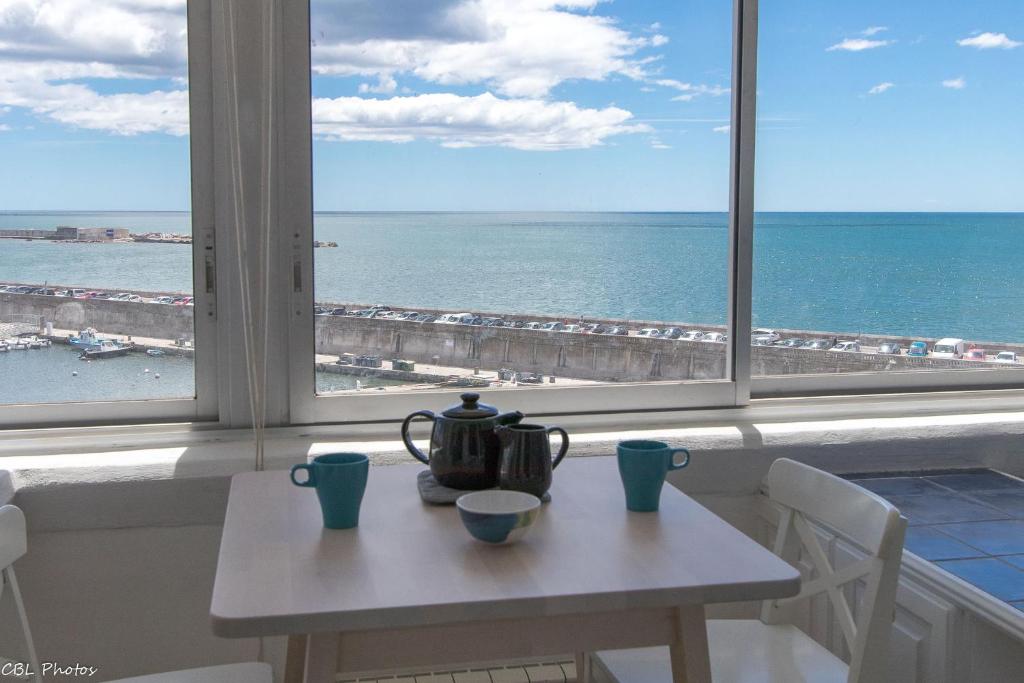 a table with a tea pot on it in front of a window at L'Eternel Estivant in Sète