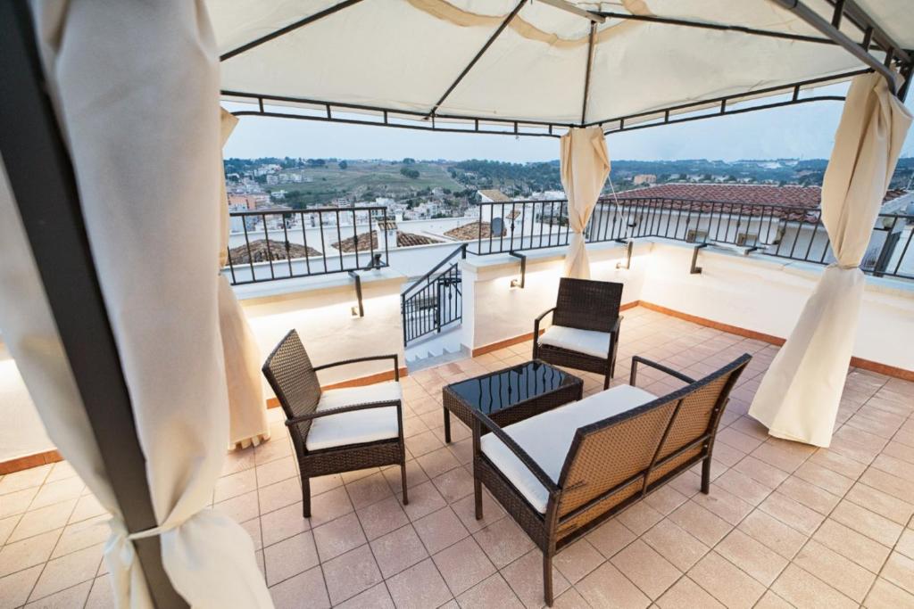 a balcony with chairs and a table and an umbrella at Il Galante B&B casa vacanza in Ginosa