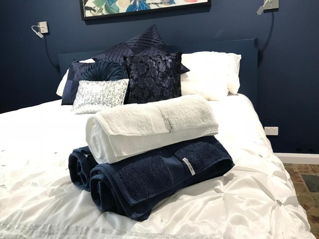 einen Stapel Handtücher auf dem Bett in der Unterkunft Adagio In Auburn in Auburn