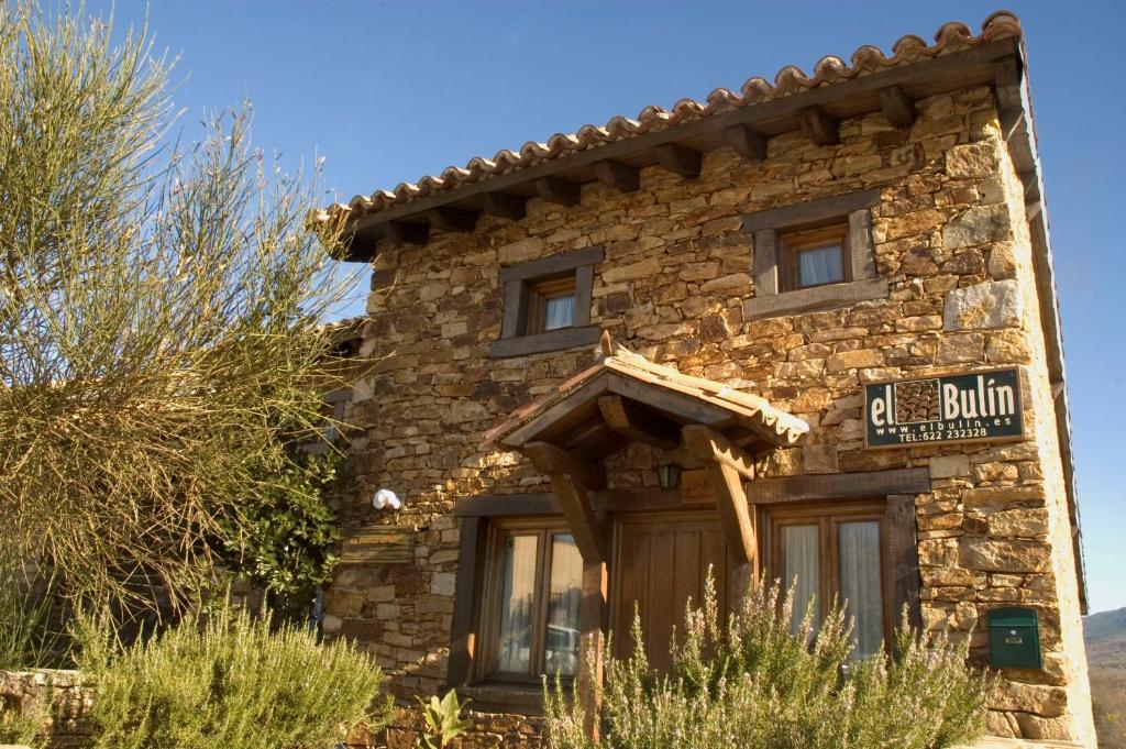 a stone building with a sign on the front of it at El Bulin de Horcajuelo in Horcajuelo de la Sierra