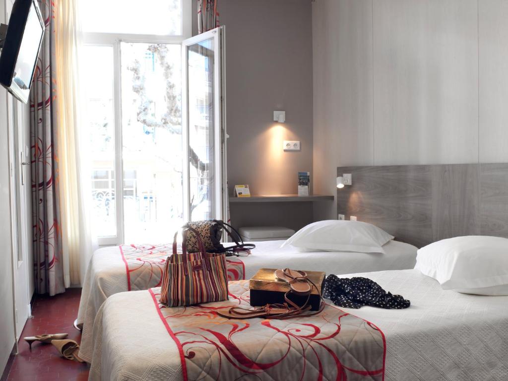 Postel nebo postele na pokoji v ubytování Brit Hotel Confort Le Revest Sainte-Maxime