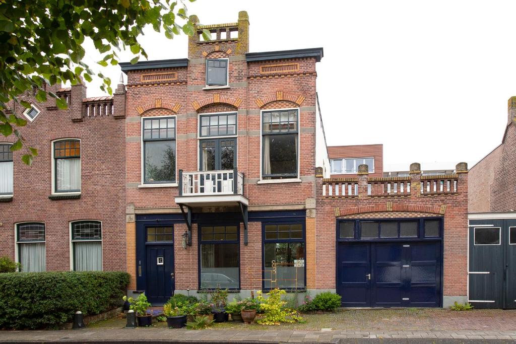 een bakstenen gebouw met zwarte deuren en een balkon bij B&B Noordwijk Binnen in Noordwijk