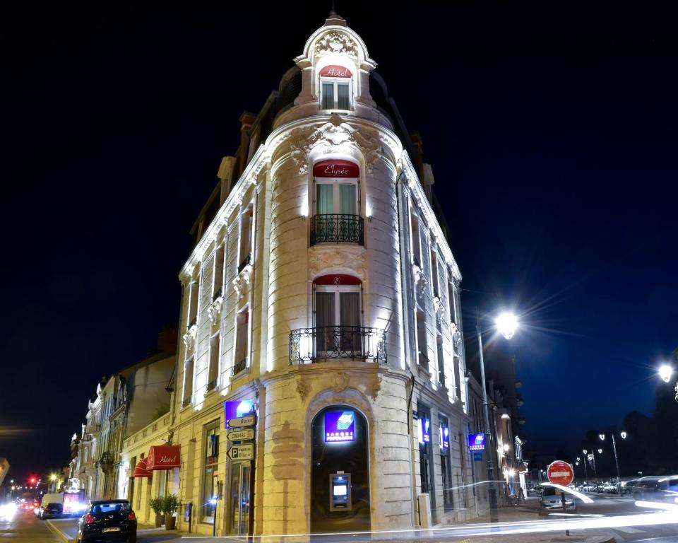 un edificio alto con un reloj encima en Élysée Hôtel, en Châteauroux