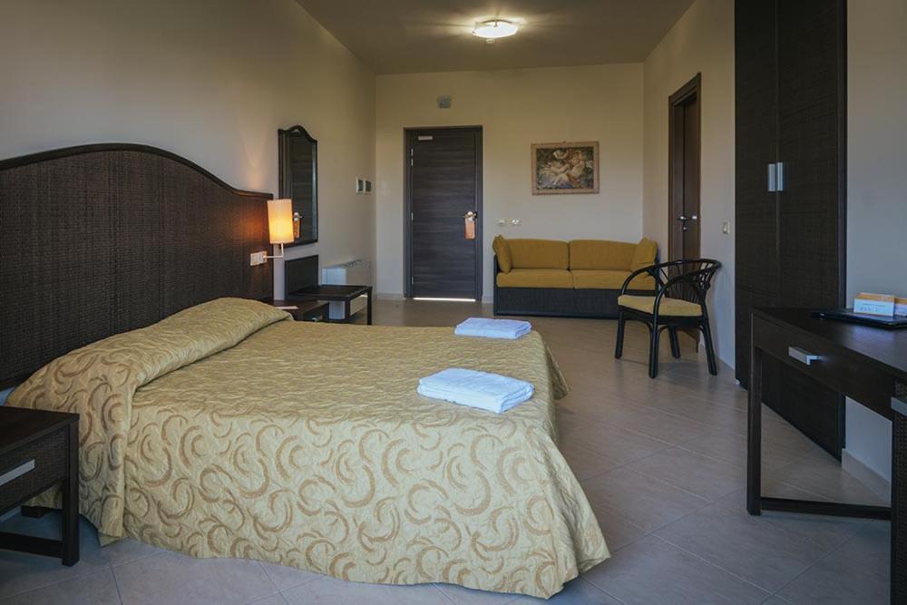 a bedroom with a bed and a living room at Hotel Costa Azul in Balestrate