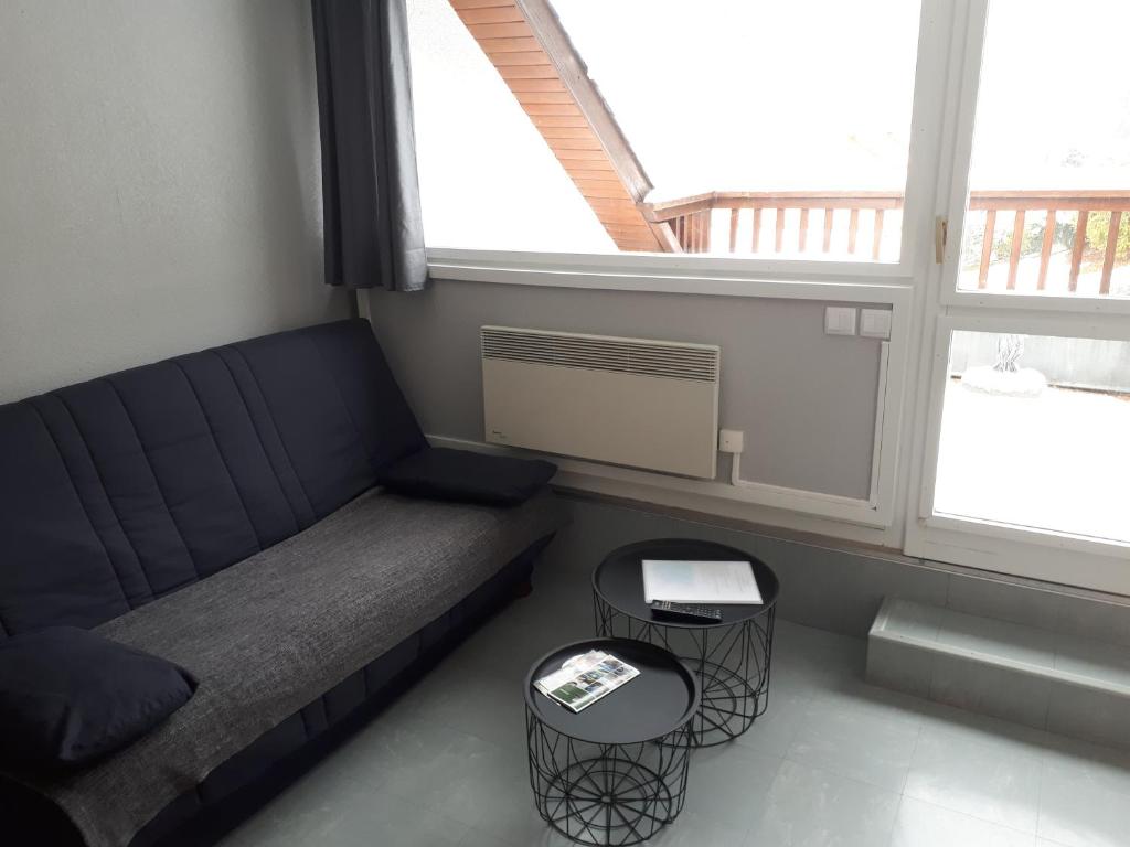 ein Wohnzimmer mit einem Sofa und 2 Tischen in der Unterkunft BEL AURE 3 in Saint-Lary-Soulan