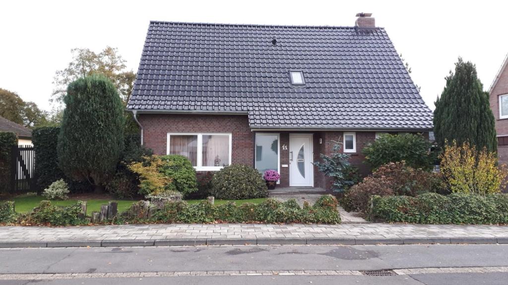 een rood bakstenen huis met een zwart dak bij Ferienwohnung Gesine in Leer