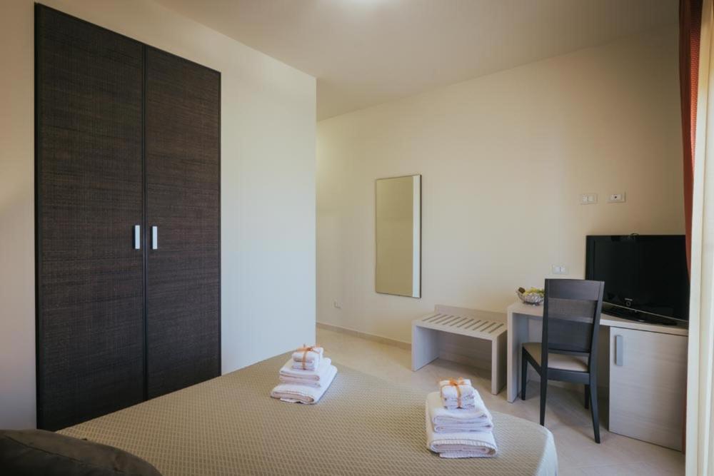 a bedroom with a bed and a chair and a table at Hotel Costa Azul in Balestrate